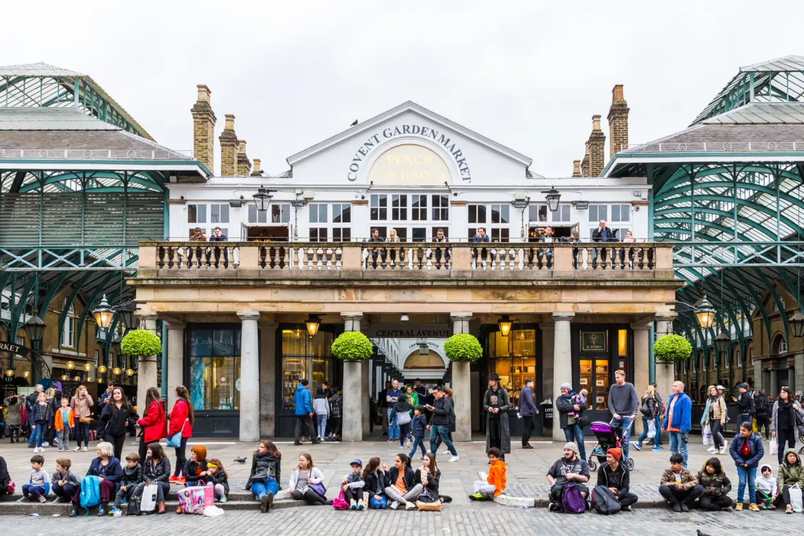 The historic Market Building and piazza of Covent Garden in London, where restaurants, boutiques, market stalls, and street performers create one of London's most vibrant and theatrical atmospheres
