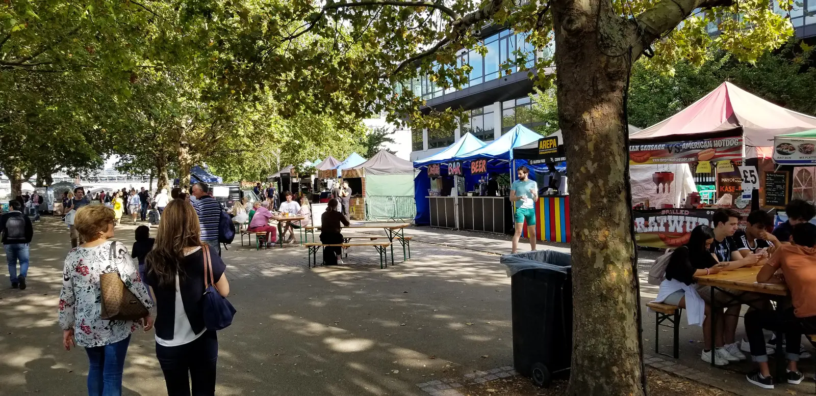 Food stalls set up along the riverside behind the Royal Festival Hall in summer, with arepa, bratwurst, and bar tents drawing crowds to picnic-bench seating. The Southbank Centre Food Market runs throughout the warmer months, particularly on weekends