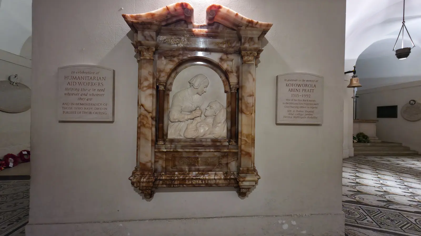 The Florence Nightingale memorial in the crypt of St Paul's Cathedral, sculpted by Arthur George Walker RA in 1916, showing Nightingale in a nurse's cap bending over a wounded soldier in his hospital bed, with the inscription Blessed Are the Merciful above and her name and dates below