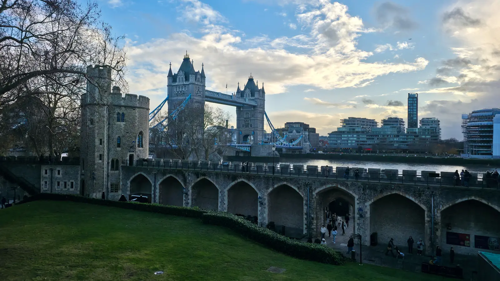 View of Tower Bridge from the grounds of the Tower of London in London, where Victorian engineering and Gothic Revival architecture rise beside one of the city's most historic medieval landmarks