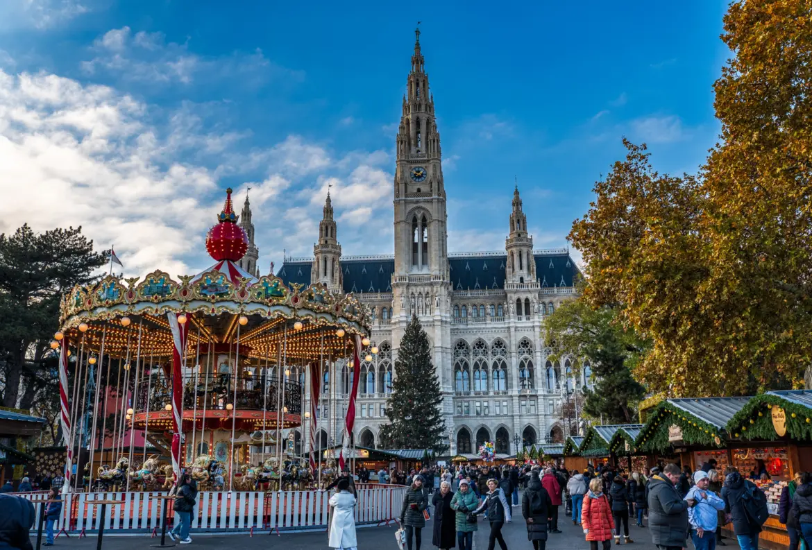 Vintage carousel and Vienna Rathaus tower at the Rathausplatz Christkindlmarkt during the Christmas season