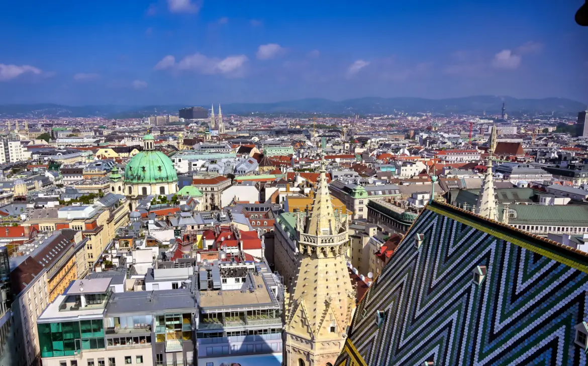Panoramic view of Vienna's historic rooftops from atop St. Stephen's Cathedral with the chevron-tile roof in the foreground