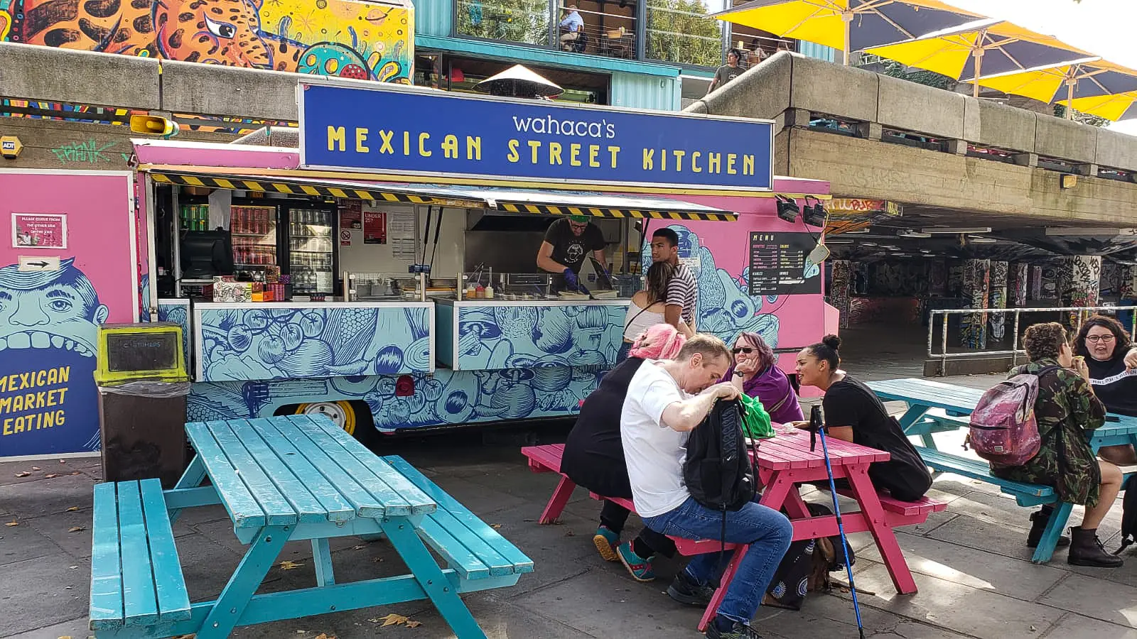 Wahaca's Mexican Street Kitchen takeaway food truck on the South Bank, parked beside the brand's flagship restaurant housed in repurposed shipping containers at Queen Elizabeth Hall