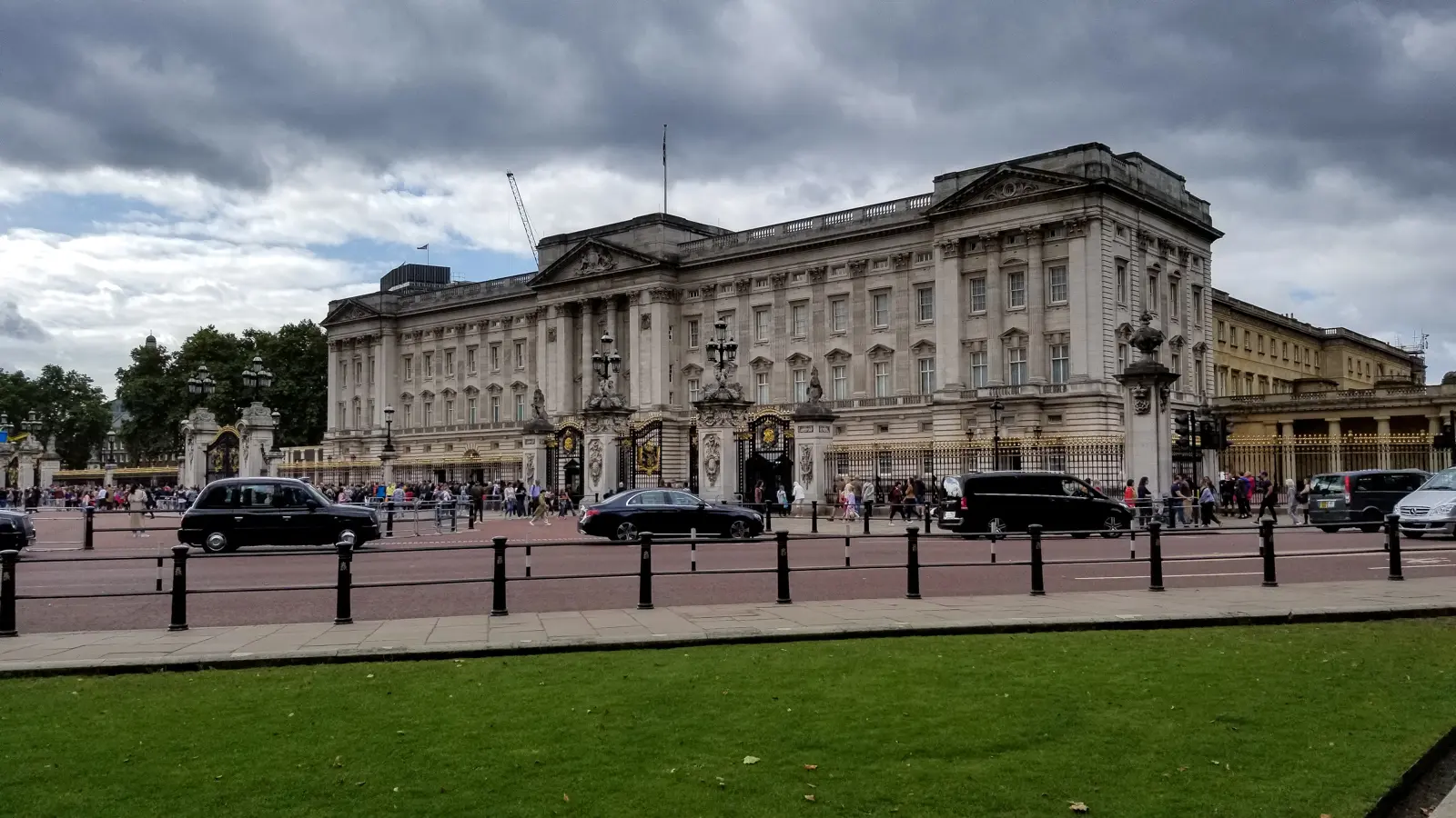 Buckingham Palace's east front from across the road, black cabs passing the gold-tipped railings