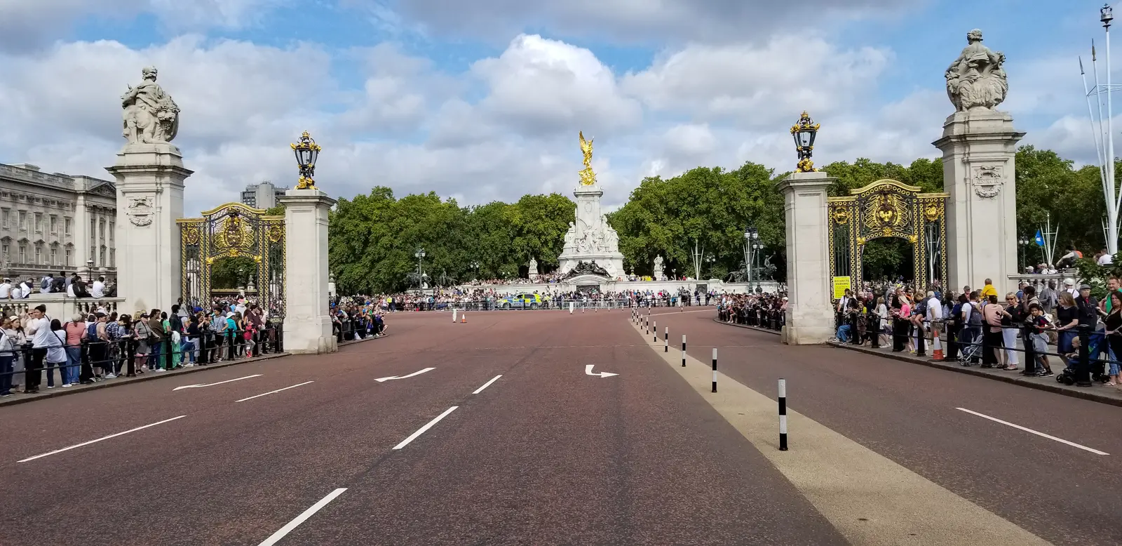 View through the Buckingham Palace gates toward the Victoria Memorial on a busy day