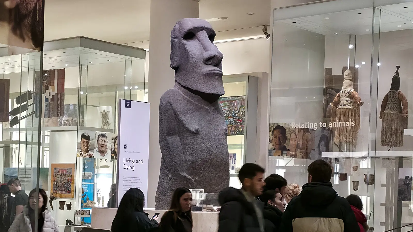 Hoa Hakananai'a among the glass cases of the Living and Dying gallery at the British Museum, London, visitors passing by