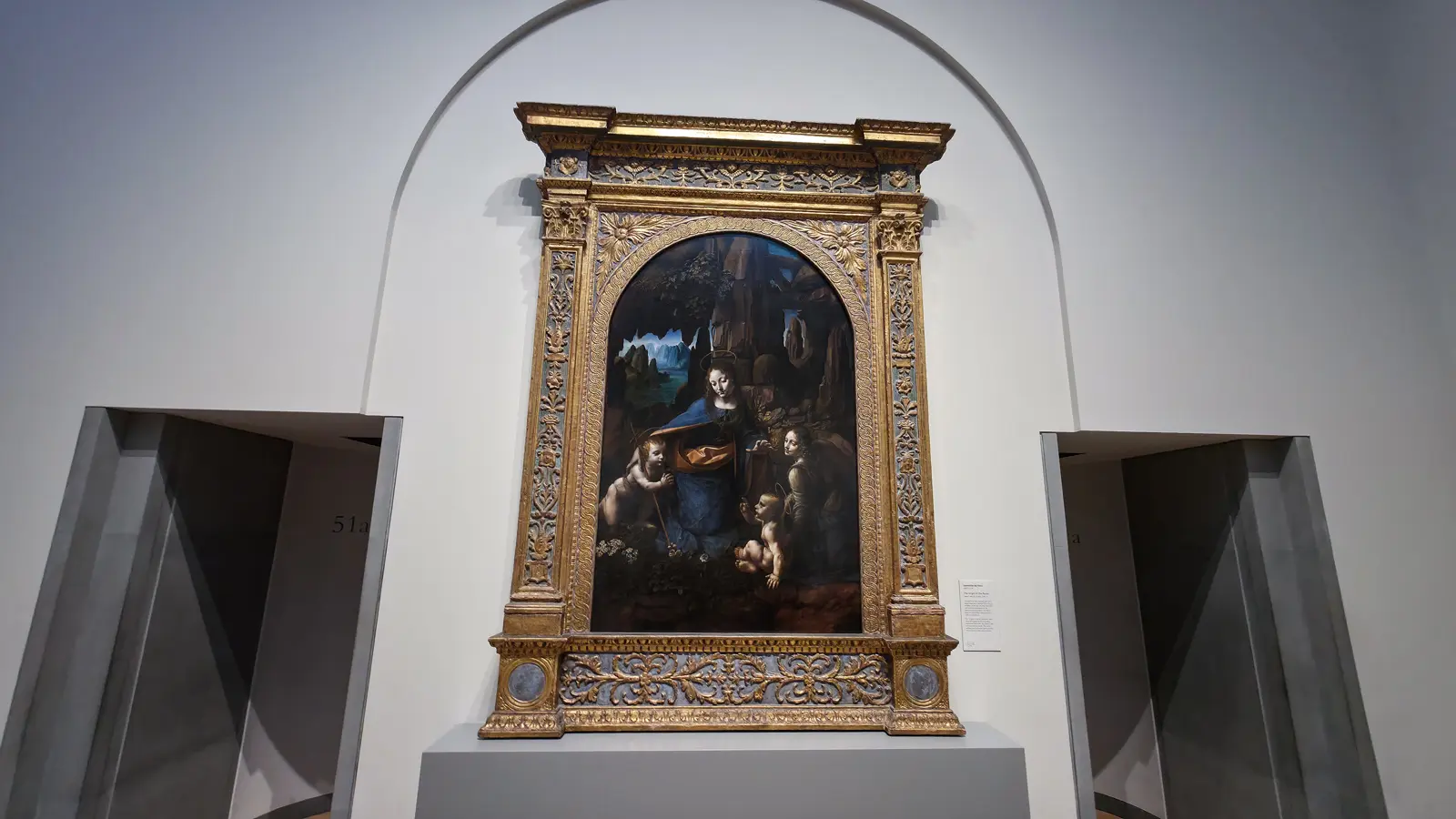 Leonardo da Vinci's Virgin of the Rocks at the National Gallery, London, the holy figures in a dark rocky grotto in an ornate gold frame.