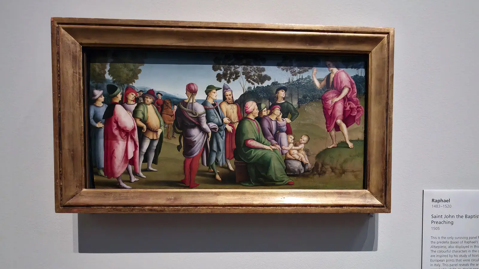Raphael's predella panel Saint John the Baptist Preaching at the National Gallery, London, the saint addressing a colourful crowd in a landscape.