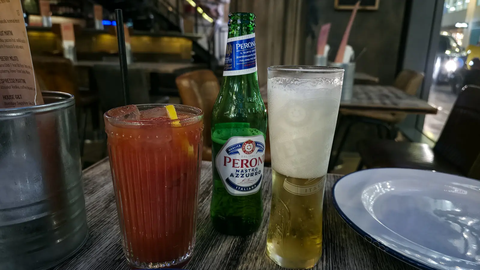 Drinks at Street Pizza by Gordon Ramsay, London: a Bloody Mary and a Peroni, poured from the bottle into the glass beside it