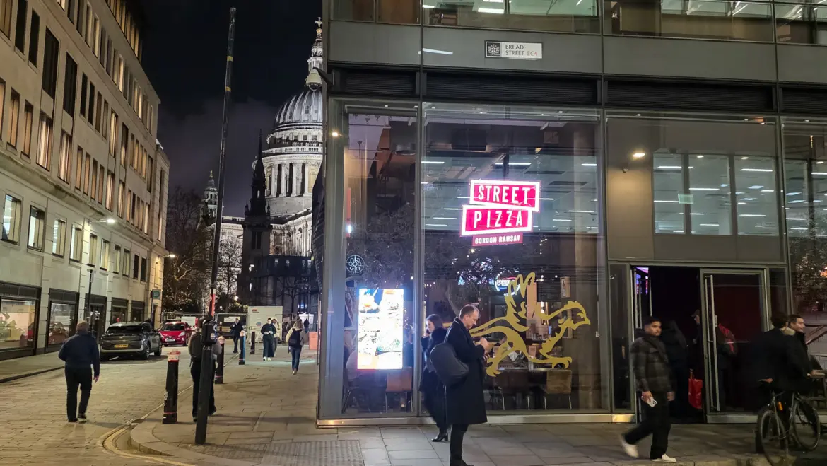 Street Pizza by Gordon Ramsay on Bread Street, London, its neon sign glowing on the corner with the dome of St Paul's lit beyond