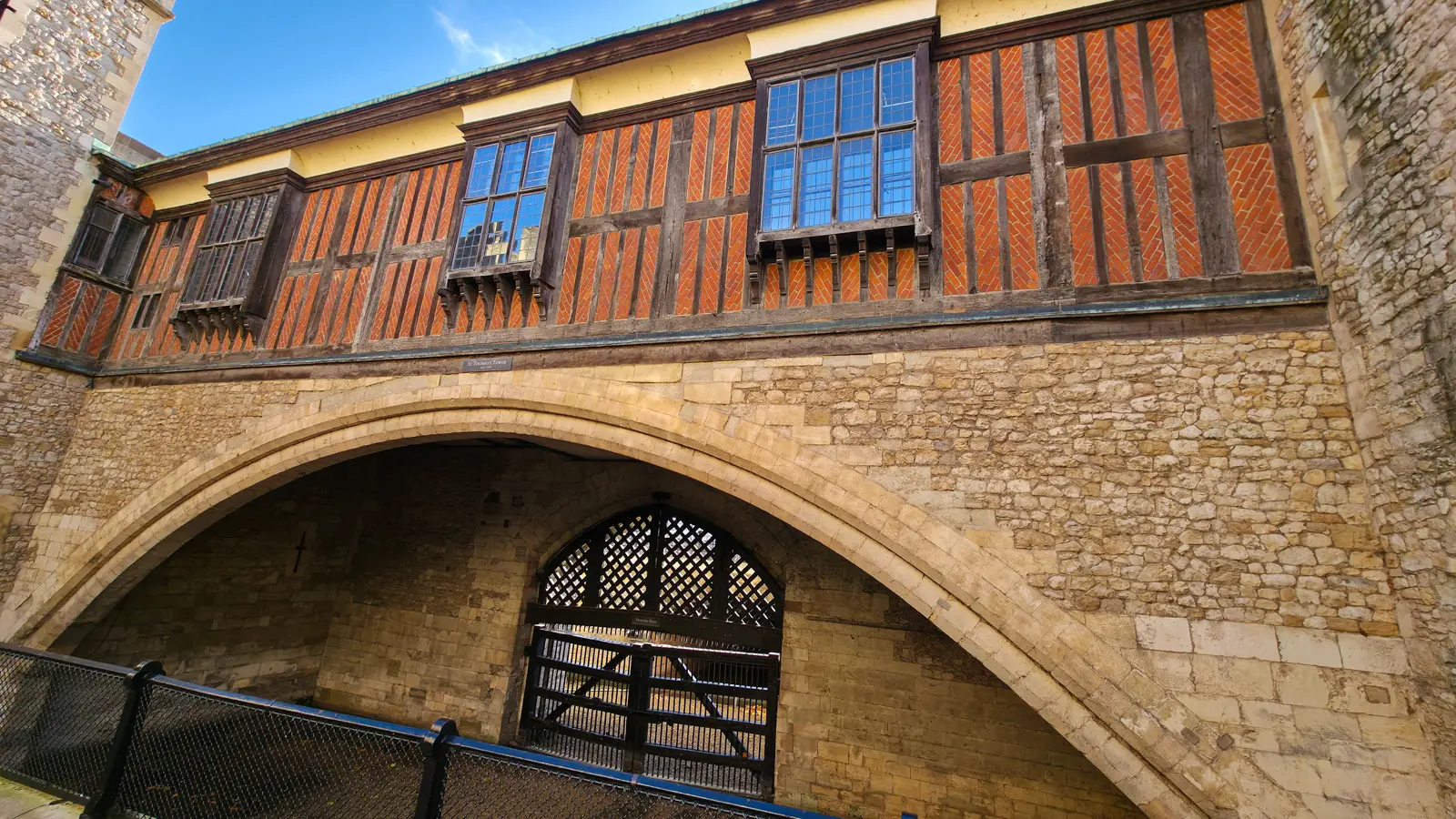 Traitors’ Gate at the Tower of London, the broad stone river arch beneath the timber-framed St Thomas’s Tower, with a dark lattice water-gate below