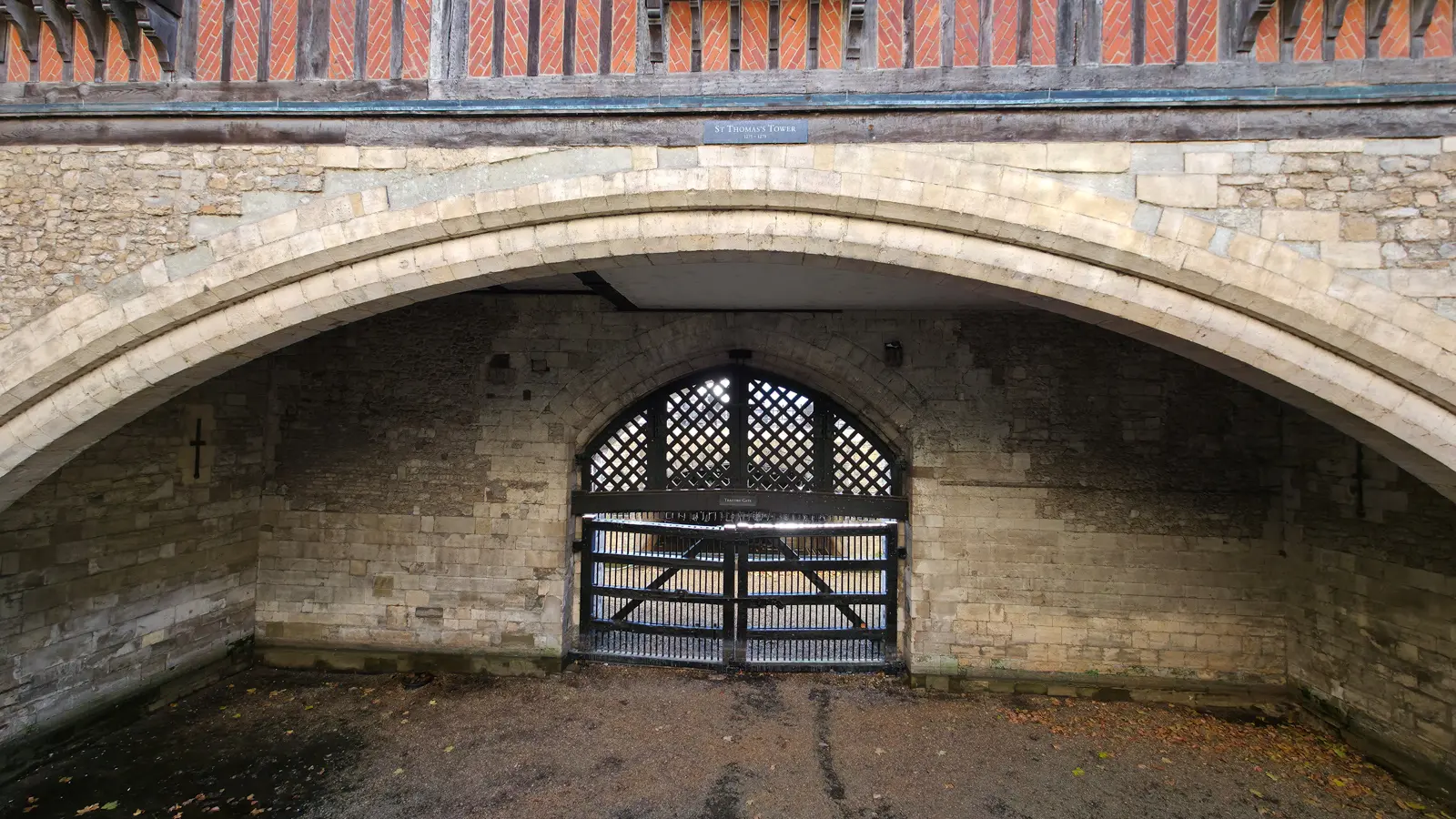 Traitors’ Gate at the Tower of London, a dark wooden lattice gate beneath the broad stone arch of St Thomas’s Tower