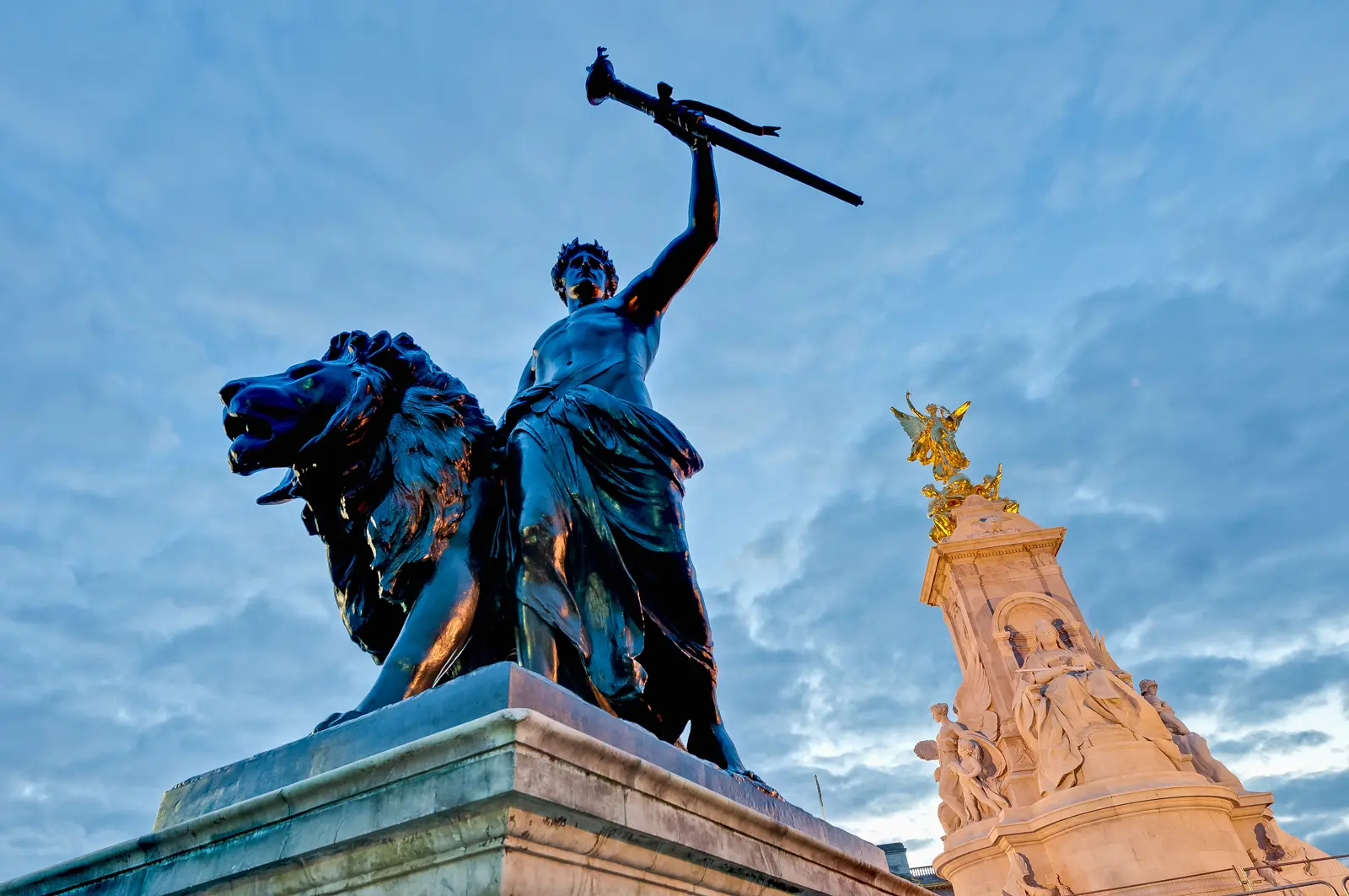 Bronze lion and figure group at the Victoria Memorial, the gilded Winged Victory rising behind