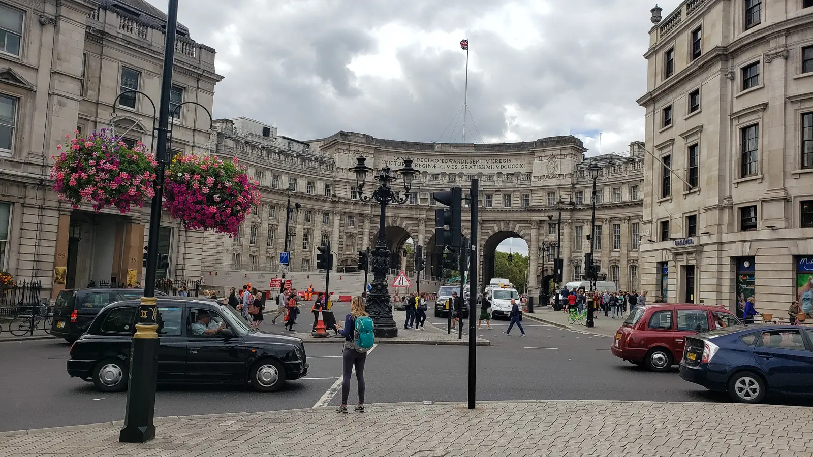 Admiralty Arch seen from the Trafalgar Square side, with taxis, hanging flower baskets and pedestrians, London