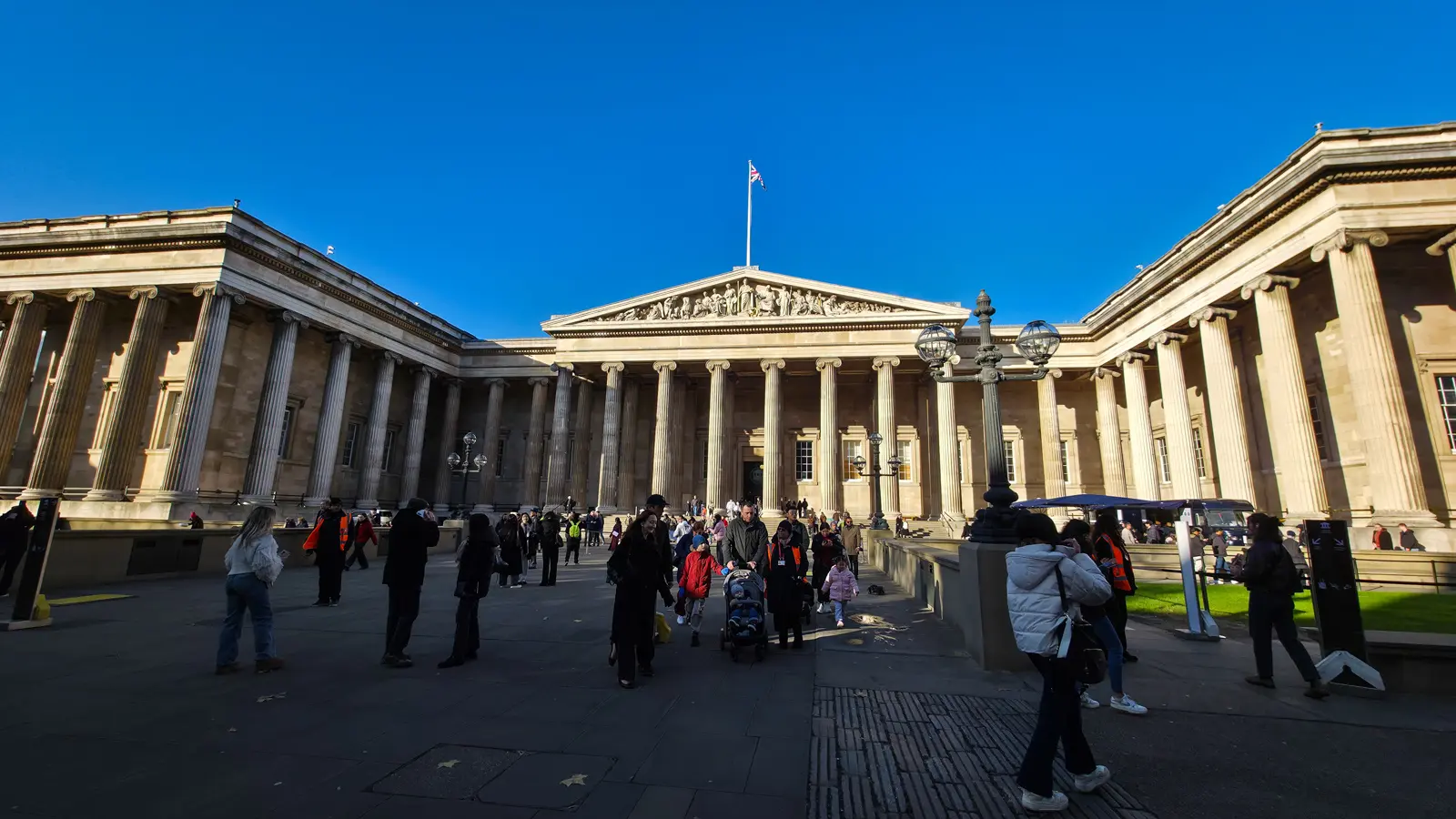 The British Museum's columned south front and forecourt under a clear blue winter sky, Bloomsbury, London
