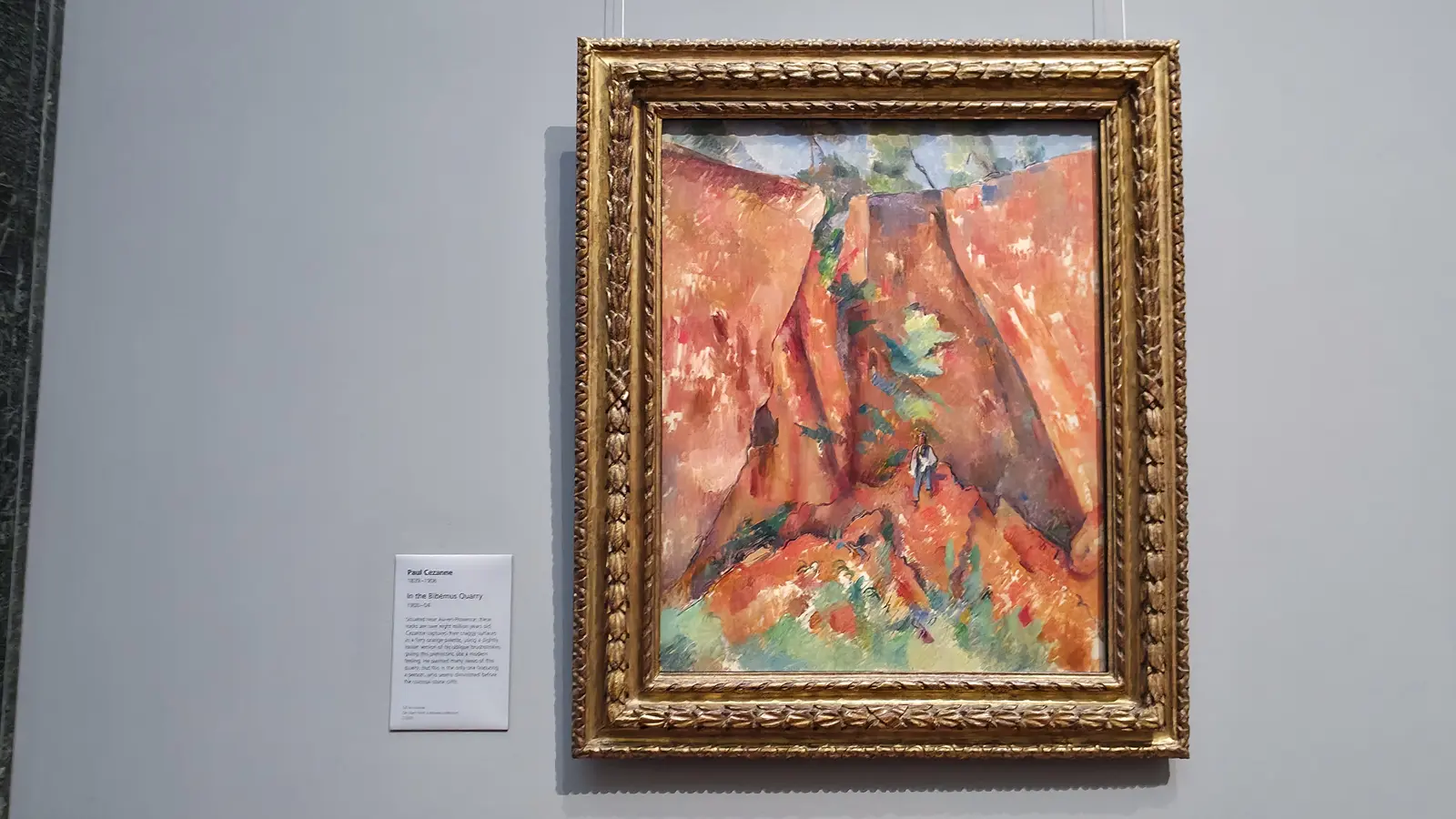 Cézanne's painting In the Bibémus Quarry, orange rock faces with a small figure, at the National Gallery, London