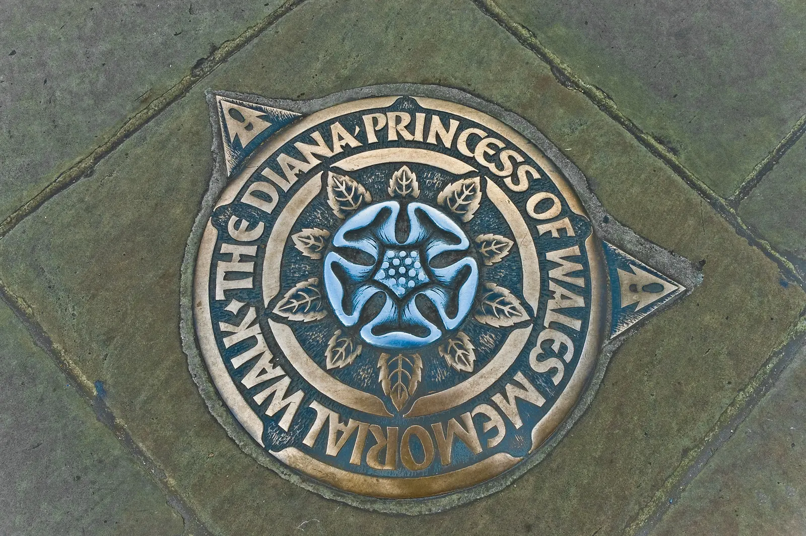 A bronze Diana, Princess of Wales Memorial Walk plaque set into the pavement, stamped with a heraldic rose, London.