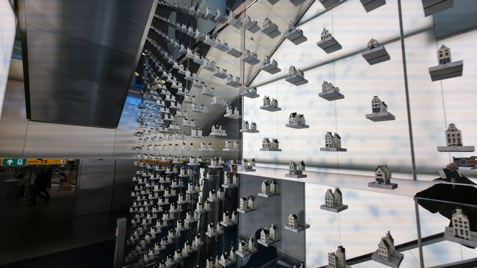 Delft Blue KLM houses on lit glass shelves and mirrored walls inside the Crown Lounge 52, Schiphol Airport