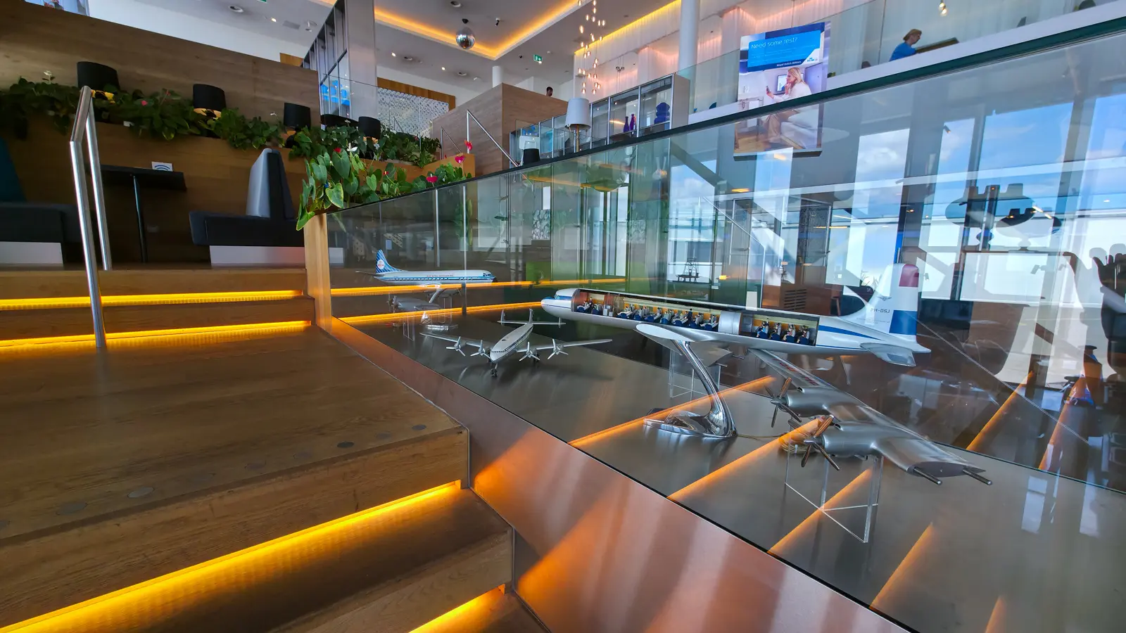Model KLM aircraft in a lit glass display case, including a cutaway showing the cabin interior, Crown Lounge 52, Schiphol