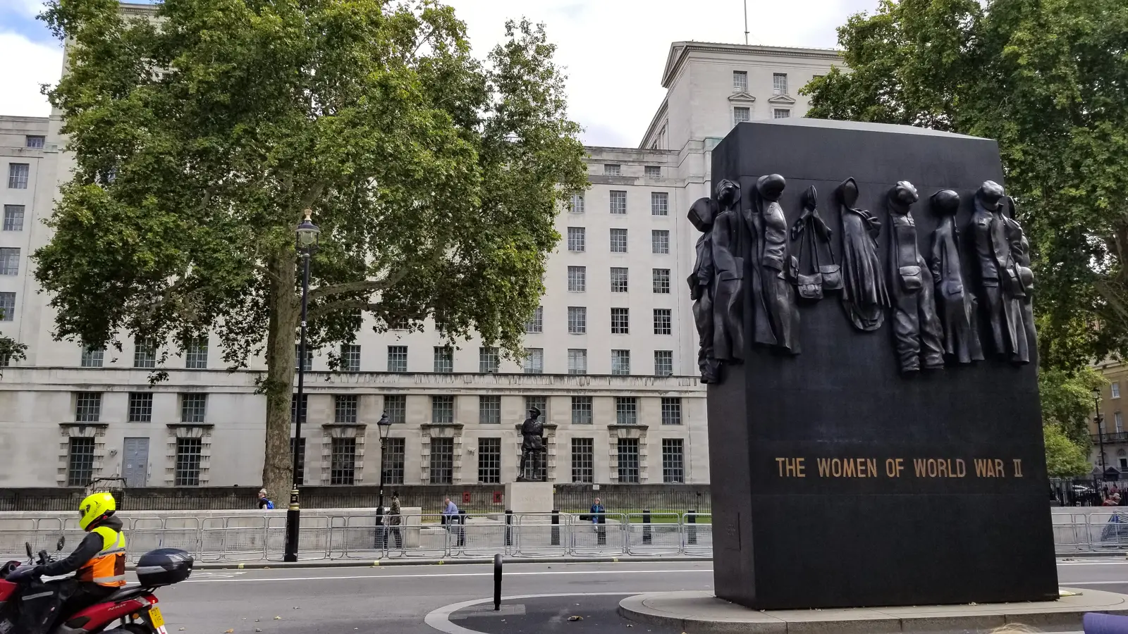 The bronze Monument to the Women of World War II on Whitehall, the Ministry of Defence building behind, London