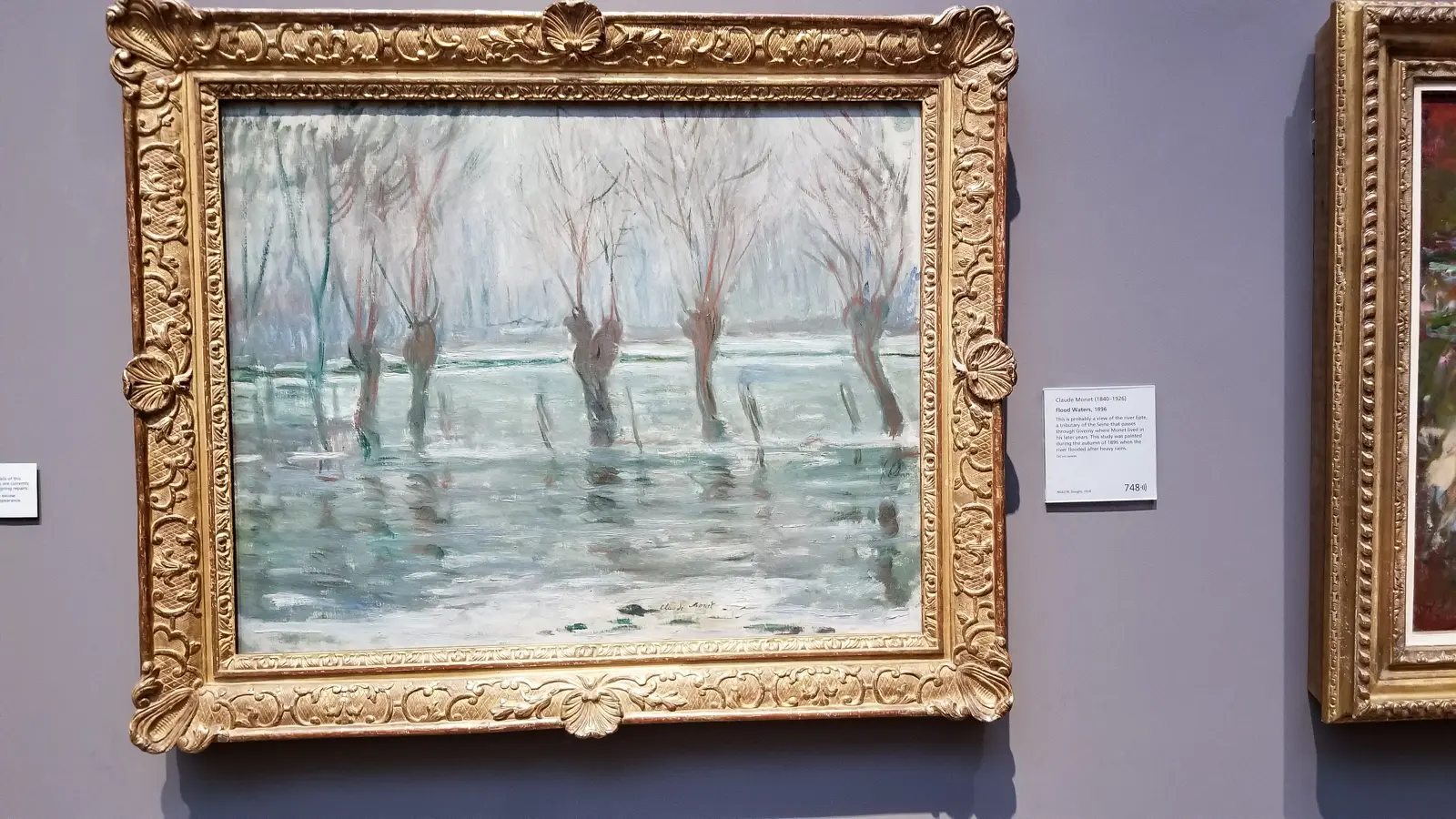 Monet's painting Flood Waters, bare willows standing in flooded water, at the National Gallery, London