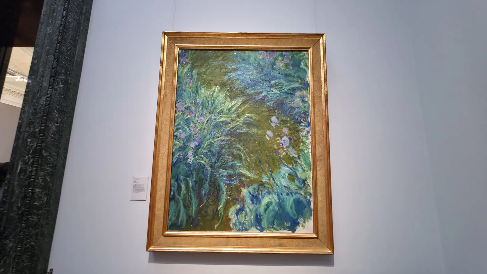 Monet's tall painting Irises, thick strokes of purple and green flowers, at the National Gallery, London