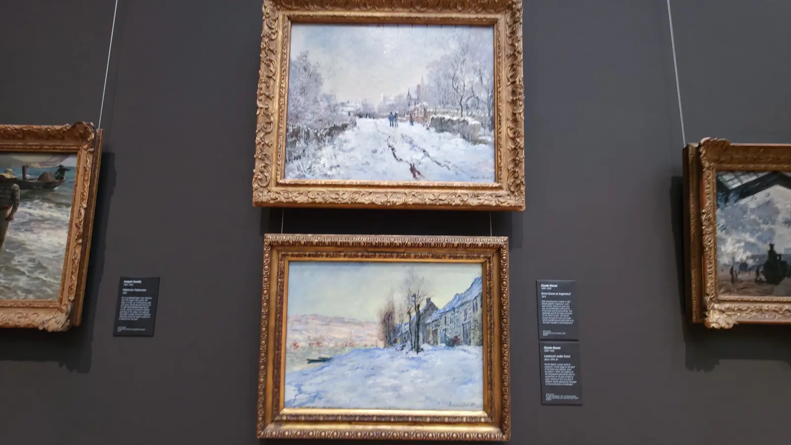 Two Monet snow scenes in gold frames hung one above the other at the National Gallery, London