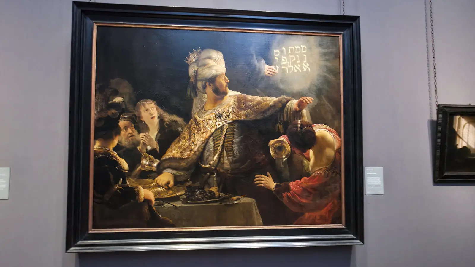 Belshazzar's Feast by Rembrandt, the Babylonian king recoiling from the glowing writing on the wall, National Gallery, London.