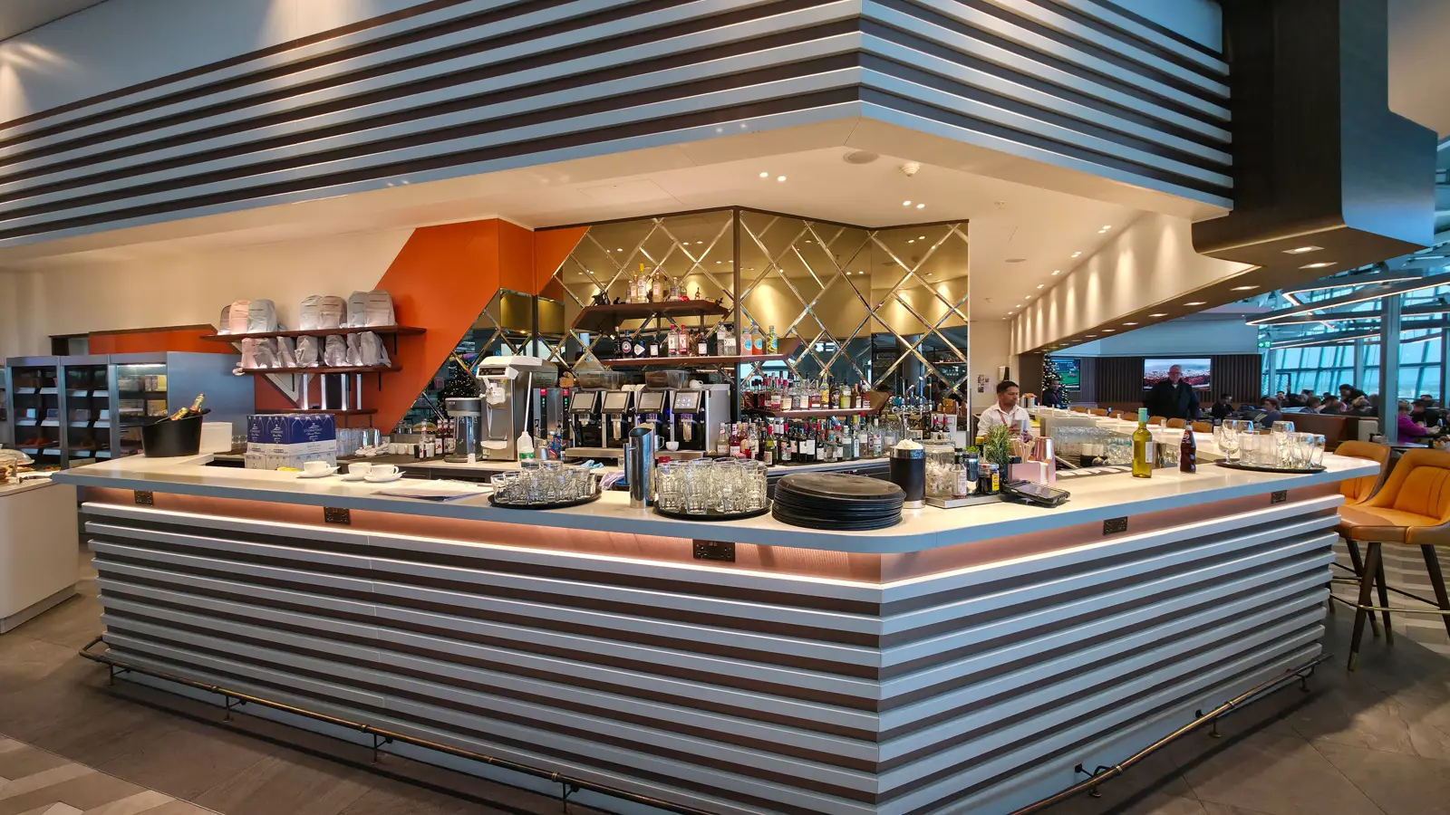 The bar at Plane Food Market, spirits and coffee machines under a mirrored back wall, Heathrow Terminal 5