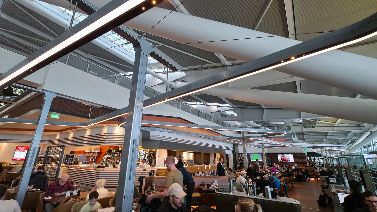 Diners under the steel struts and skylights of Terminal 5 at Gordon Ramsay Plane Food Market, Heathrow