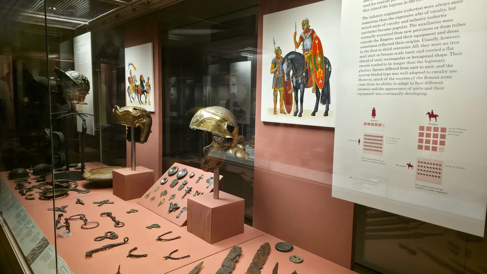 A display case of Roman cavalry helmets, harness fittings and weapons in the Roman Britain gallery at the British Museum