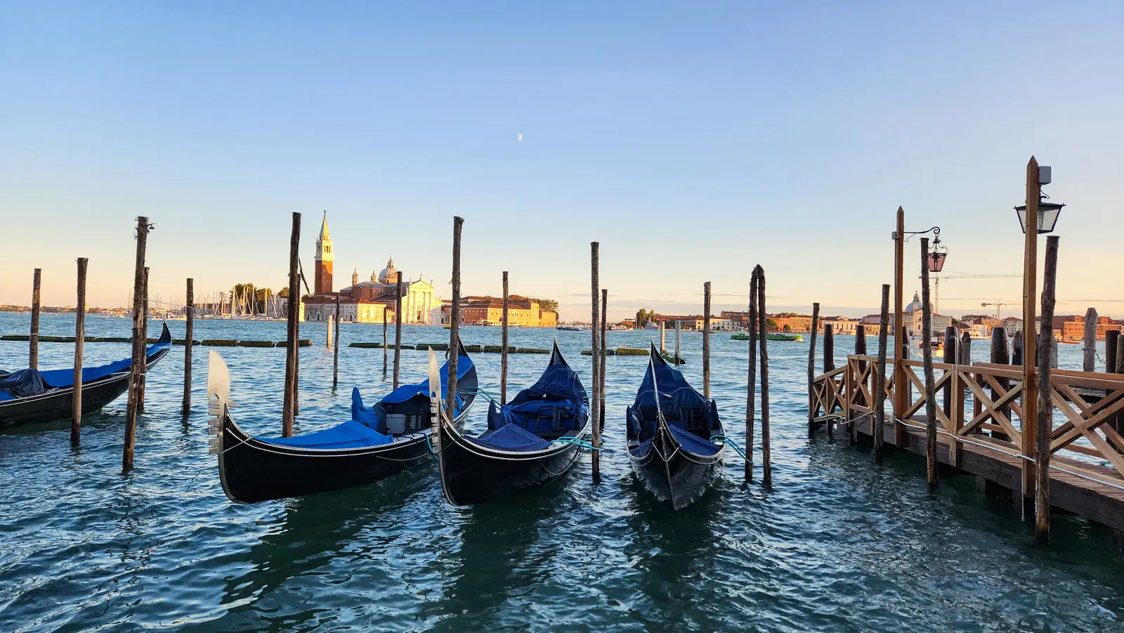 Moored gondolas at the Molo with San Giorgio Maggiore across the Basin of San Marco at dusk, Venice