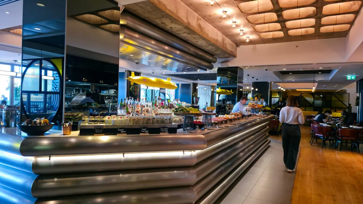 The breakfast buffet at Sea Containers Restaurant, cold stations along a steel counter with the restaurant's yellow submarine overhead, South Bank London