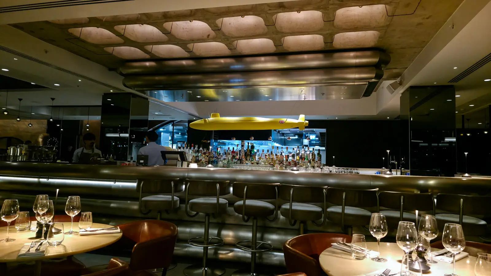 The bar and open kitchen at Sea Containers Restaurant in London, with a yellow submarine sculpture suspended above the counter