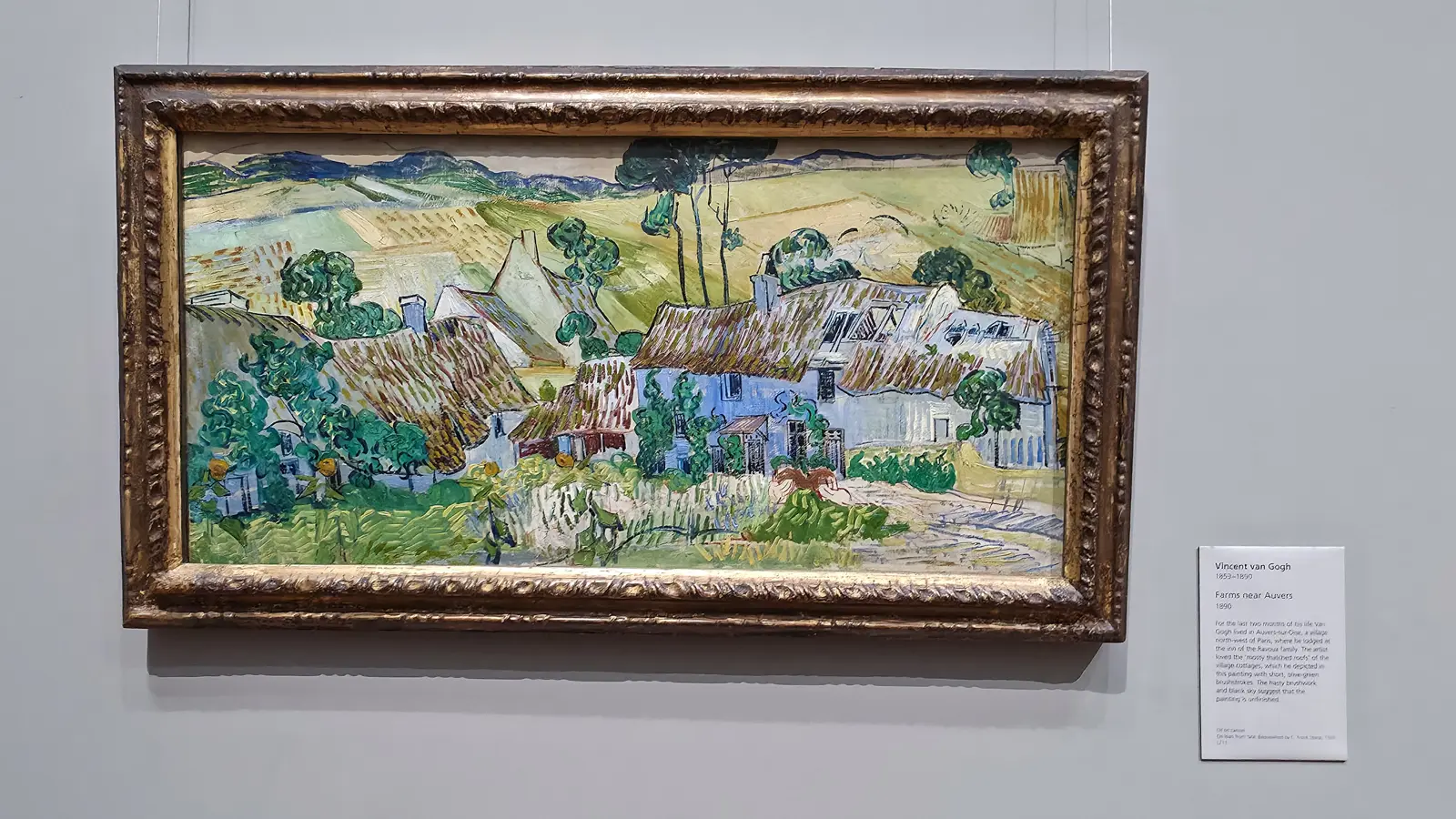 Van Gogh's Farms near Auvers, thatched cottages beneath green hills, in a wide gilt frame