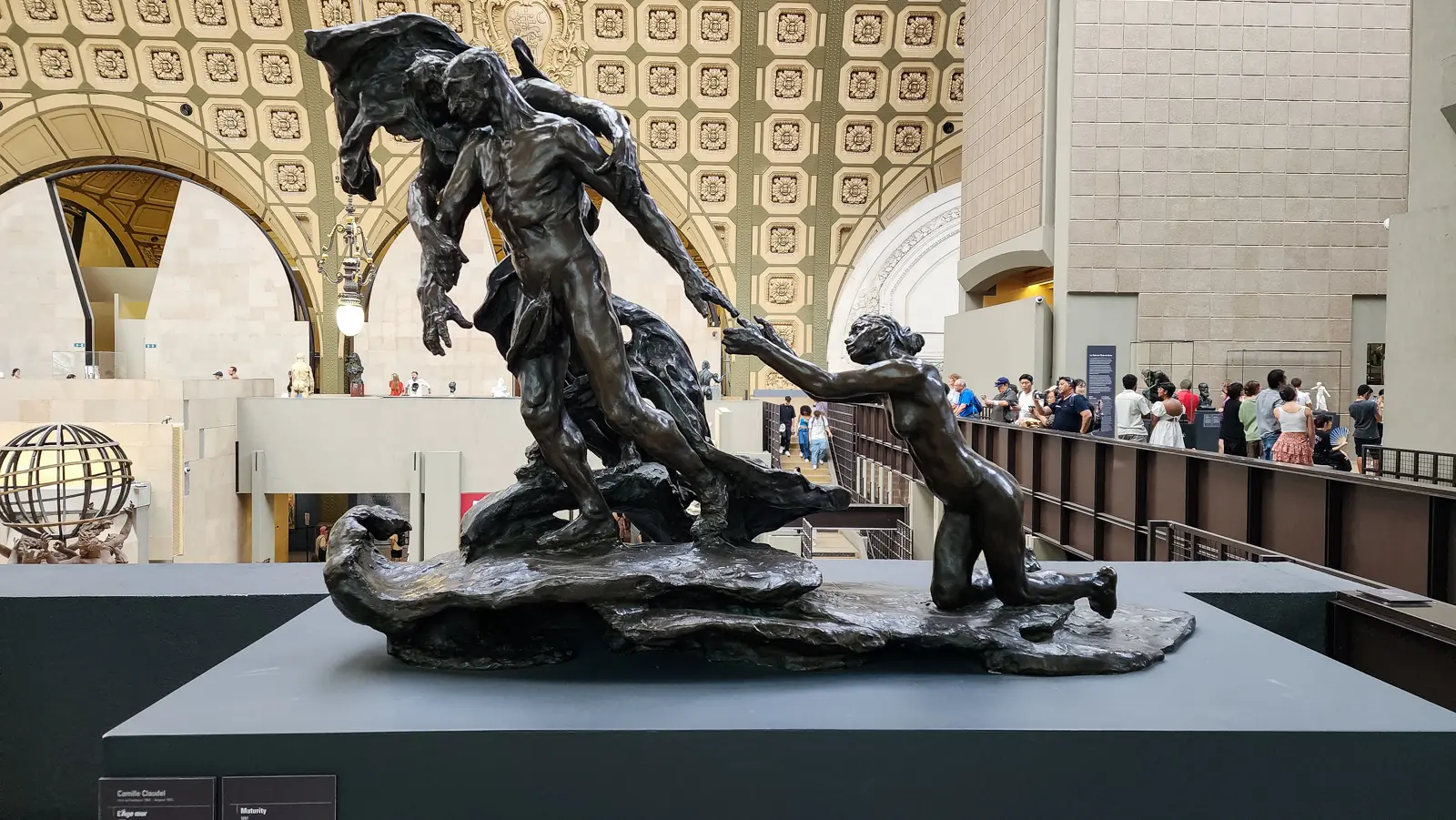 Camille Claudel’s The Mature Age at the Musée d’Orsay, three bronze figures on a low plinth beneath the museum’s coffered vault