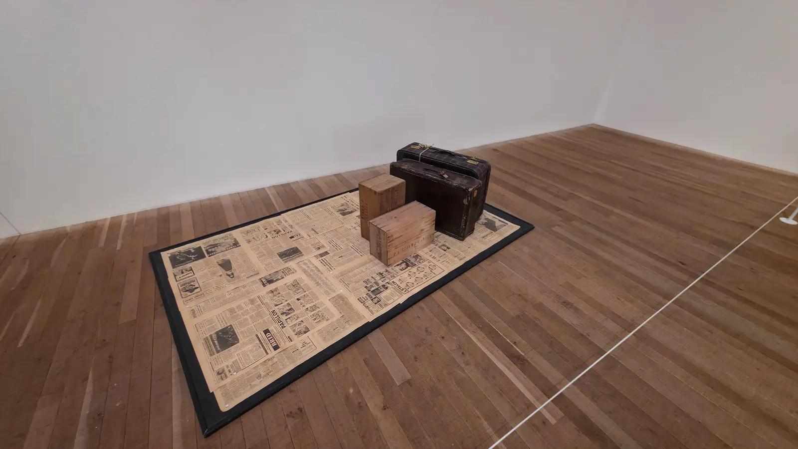 Vlassis Caniaris’s Image (1971) at Tate Modern, newspapers spread as a floor, packing cases for chairs and battered suitcases