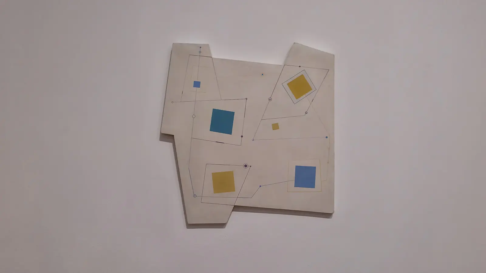 Carmelo Arden Quín’s Squares (1951) at Tate Modern, small blue and yellow squares on an irregularly shaped, cut-away white panel