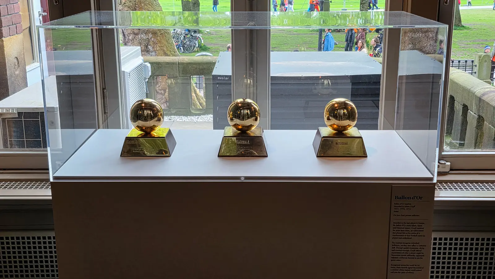 Three Ballon d’Or trophies awarded to Johan Cruyff, displayed in a glass case at the Moco Museum Amsterdam