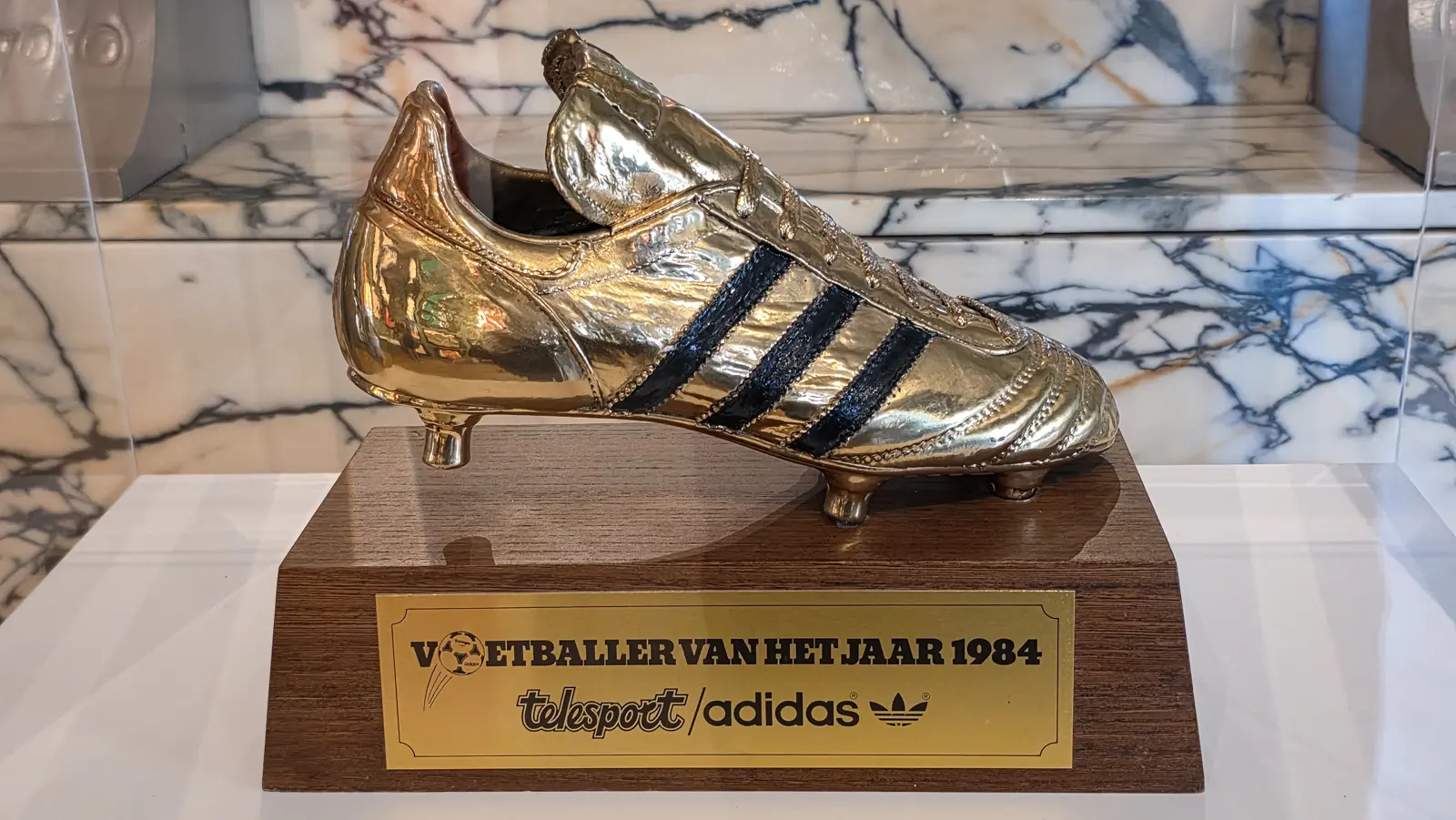 A gold football boot trophy awarded to Johan Cruyff, with adidas stripes and an engraved plate, at the Moco Museum Amsterdam