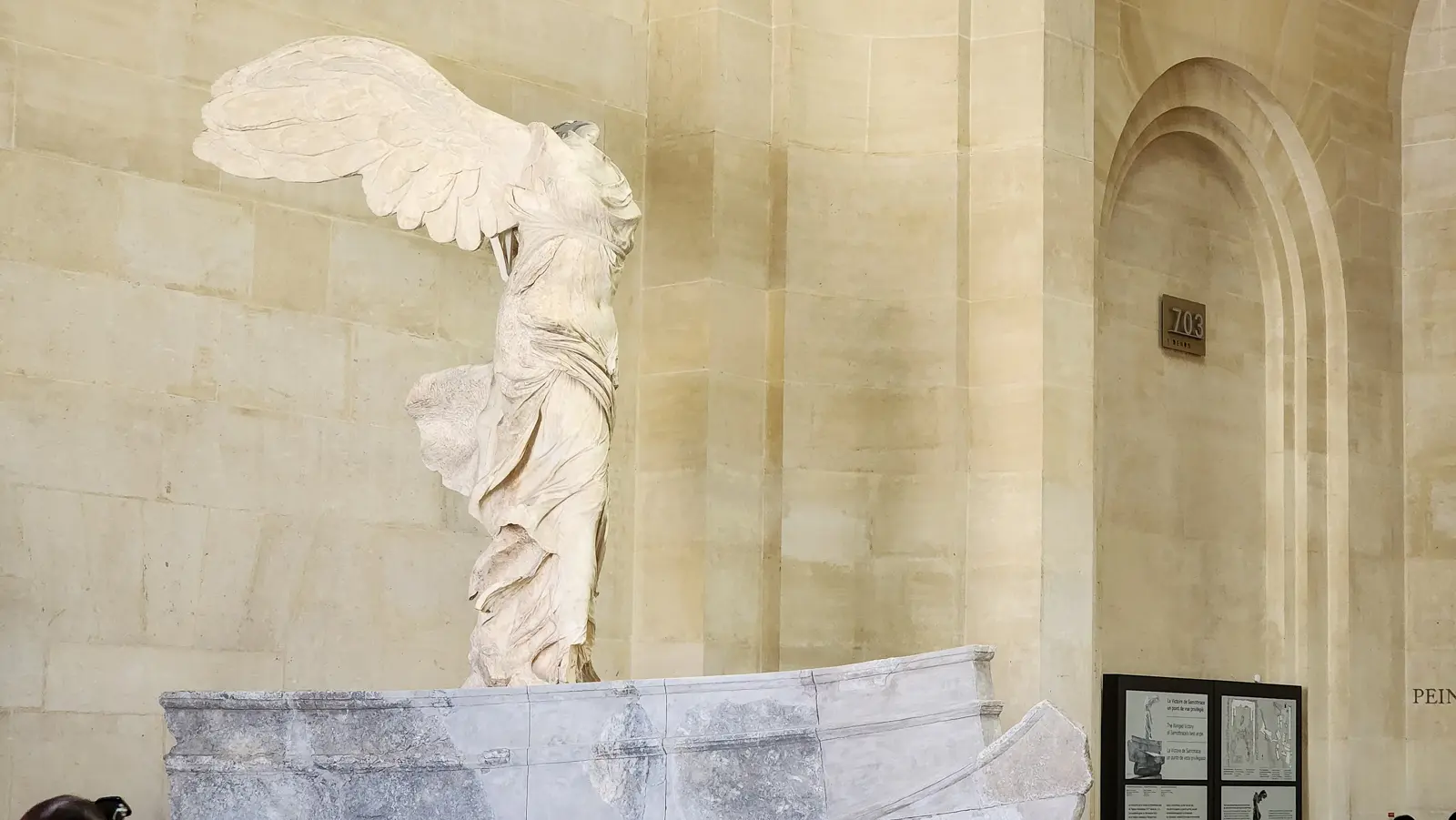 The Winged Victory of Samothrace on her marble ship’s prow at the Louvre, one wing raised, drapery pressed against the body