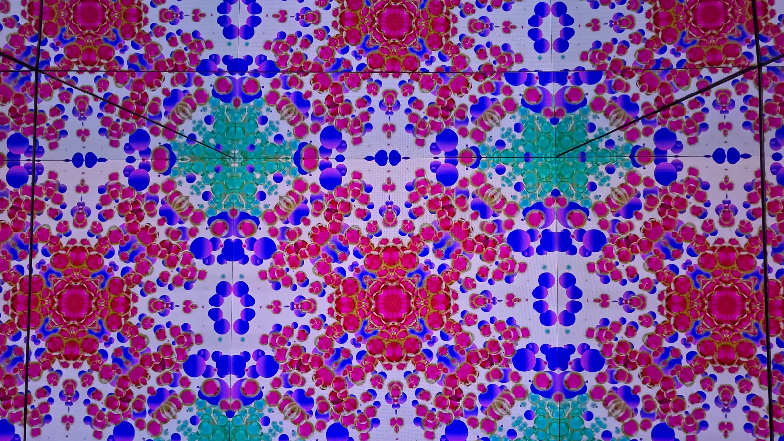 The Kaleidoscope room at Moco Museum Amsterdam, mirrored walls carrying symmetrical pink, blue and gold circular patterns