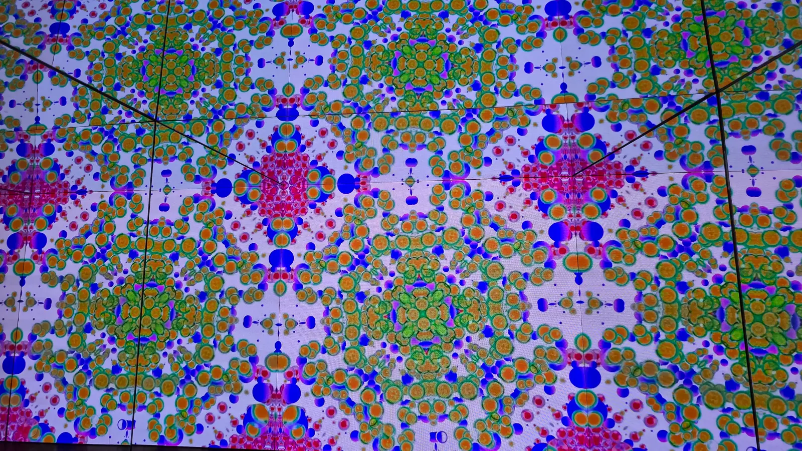The Kaleidoscope room at Moco Museum Amsterdam in a warmer colourway, with orange, green and red symmetrical patterns