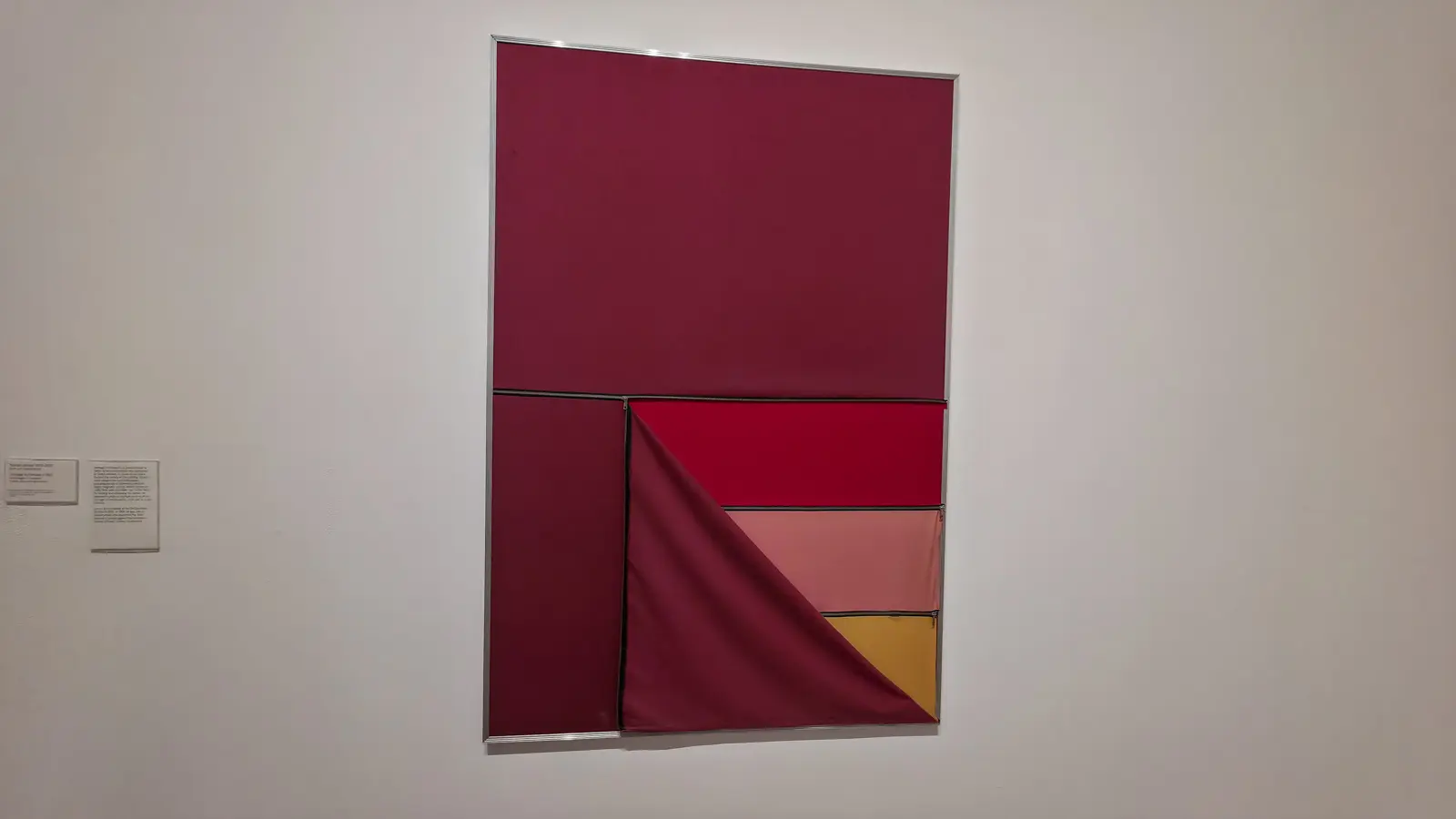 Nelson Leirner’s Homage to Fontana II (1967) at Tate Modern, a deep red fabric panel with zips opened to crimson, pink and gold