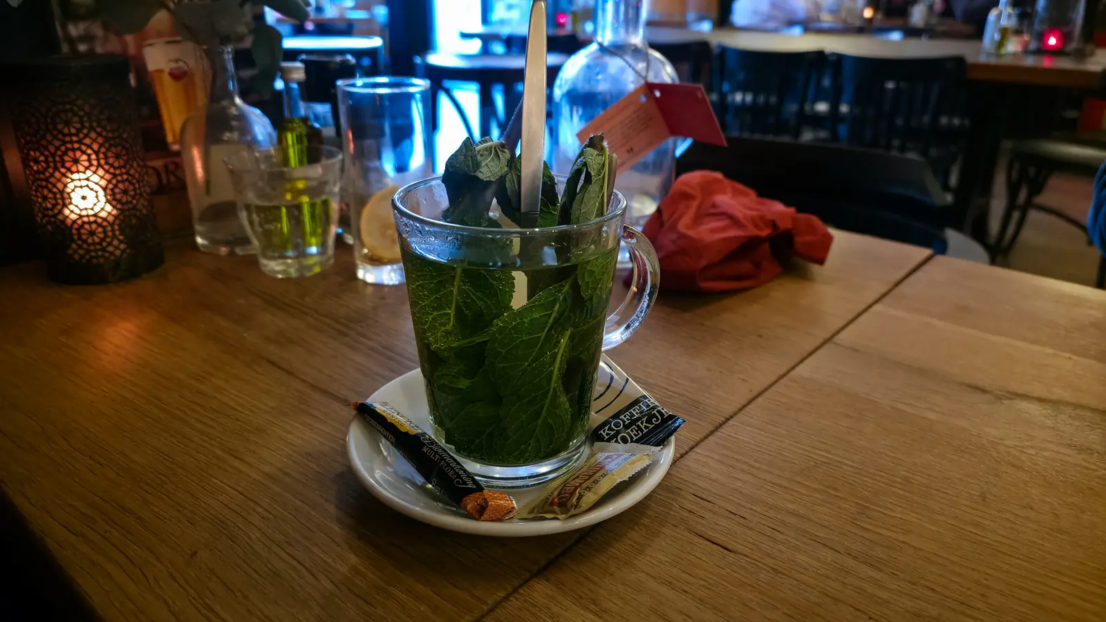 A glass of fresh mint tea at Oresti’s Taverna, the glass packed with mint leaves, with honey and sugar on the saucer