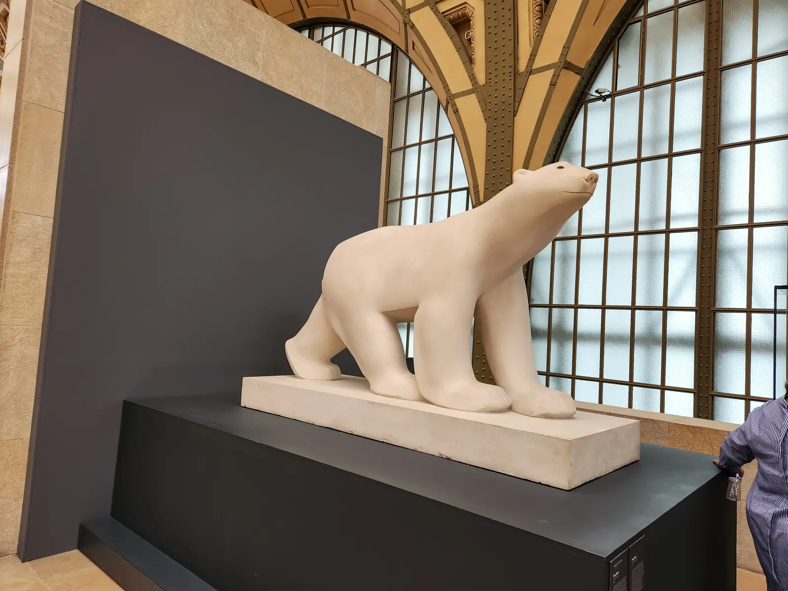 François Pompon’s White Bear at the Musée d’Orsay, a smooth pale stone bear walking on a low plinth beneath the station’s iron arches
