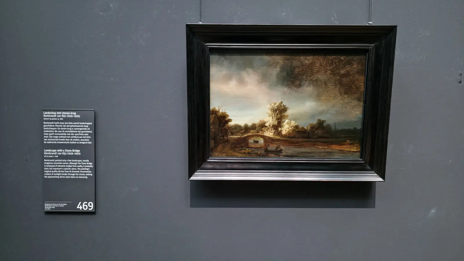 Rembrandt’s Landscape with a Stone Bridge at the Rijksmuseum, a small dark panel showing a bridge, a river and a stormy sky
