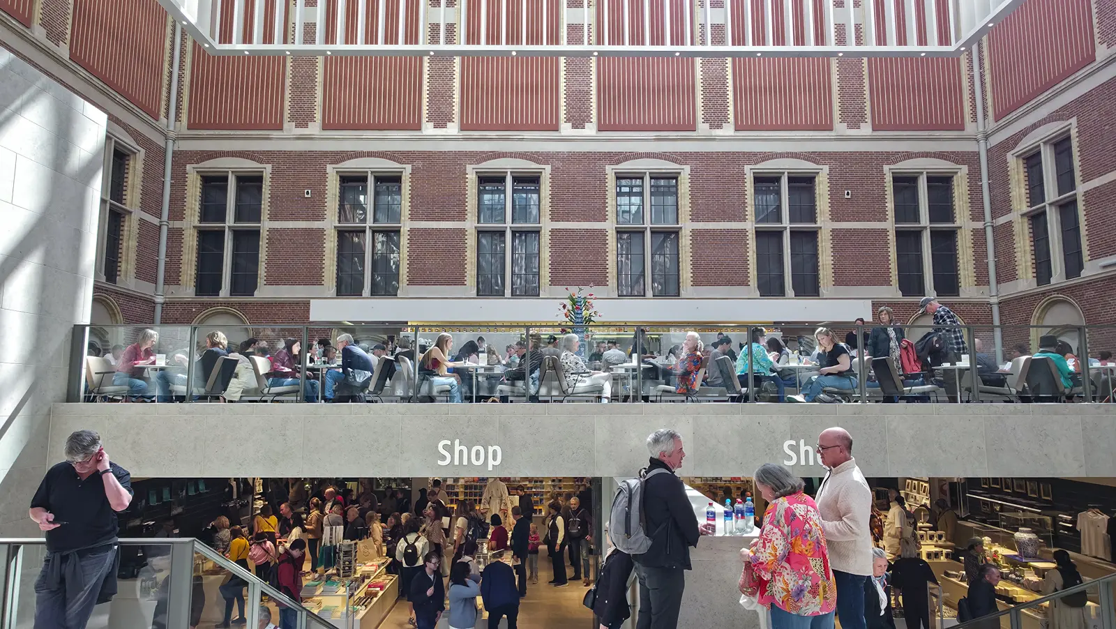 The shop and the café at the Rijksmuseum, set on two levels beneath the brick courtyard walls of the atrium