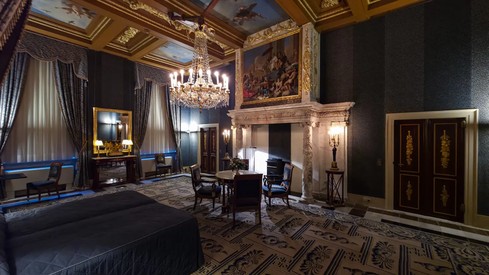A blue bedroom in the Royal Palace Amsterdam with painted ceiling panels, a marble chimneypiece and a large gilt-framed painting