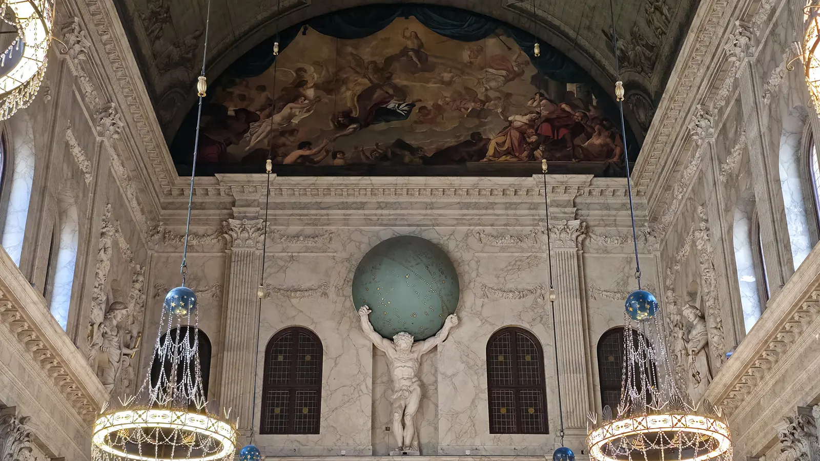 The marble Atlas figure at the end of the Citizens’ Hall in the Royal Palace Amsterdam, carrying a celestial globe beneath a painted ceiling